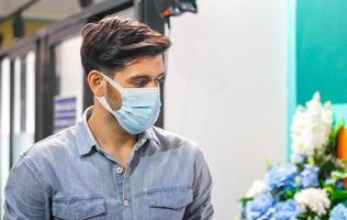 un jeune homme d'affaires porte un masque de protection contre le coronavirus, un travailleur licencié porte un masque facial en partant du bureau, un employé licencié dans une épidémie de covid-19 photo