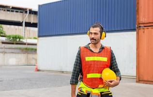 portrait d'un ingénieur en gilet de sécurité, d'un travailleur avec un casque de protection et un casque sur le chantier de construction photo