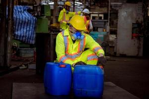 l'industrie des ingénieurs portant un uniforme de sécurité, des gants noirs, un masque à gaz se sent étouffé lors de la vérification du réservoir de produits chimiques dans le travail en usine de l'industrie. photo