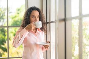 belle femme latine buvant du café photo