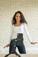 une femme latine a créé sa vidéo de danse avec l'appareil photo d'un smartphone. pour partager la vidéo à l'application de médias sociaux.