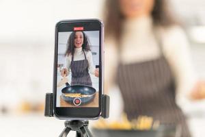 femme latine filmant une vidéo et cuisinant dans la cuisine photo