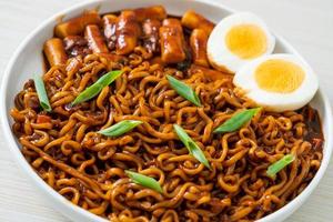 jjajang rabokki - nouilles instantanées coréennes ou ramyeon avec gâteau de riz coréen ou tteokbokki et œuf à la sauce aux haricots noirs photo