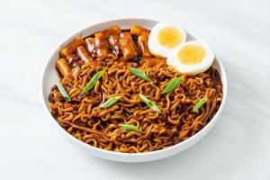 jjajang rabokki - nouilles instantanées coréennes ou ramyeon avec gâteau de riz coréen ou tteokbokki et œuf à la sauce aux haricots noirs photo