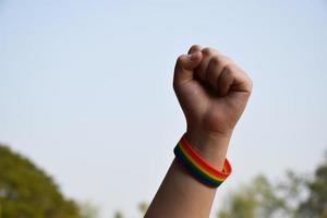 bracelets arc-en-ciel aux poignets d'un couple de garçons asiatiques avec arrière-plan flou, concept pour la célébration de la communauté lgbt pendant le mois de la fierté ou en juin dans le monde entier photo