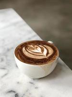 art latte chaud sur une tasse de café sur la table photo
