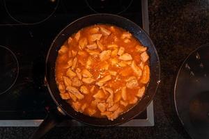 viande de poulet au curry de sauce tomate dans une poêle à frire faire cuire les repas photo