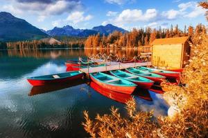 bateau sur le quai entouré de montagnes. fantastique shtrbske pleso photo