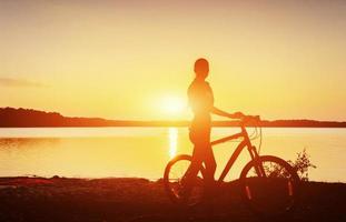 garçon sur un vélo au coucher du soleil photo