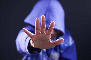 homme triste au visage de couverture de capot avec des mains isolées en noir. photo