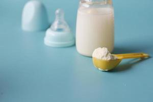 gros plan de lait en poudre pour bébé et cuillère sur fond de tuile. photo