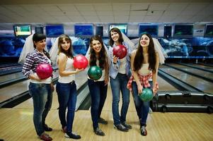 groupe de six filles avec des boules de bowling à la fête de poule au club de bowling. photo