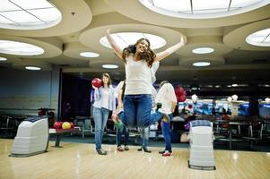 groupe de filles s'amusant et jouant au bowling à la fête de poule. photo