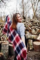 jeune fille hipster porter sur une couverture contre des souches en bois sur bois. photo