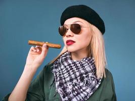 Portrait de belle femme blonde au chapeau et lunettes de soleil avec cigare dans le style cubain che guevara photo