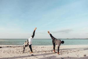 deux hommes s'entraînent à l'art martial de capoeira sur la plage photo