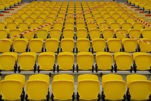 les sièges des terrains de football étaient bloqués, les chaises jaunes sur le terrain de football interdisaient aux gens de s'asseoir. photo