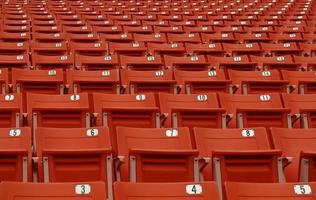 le siège pour regarder le football a un numéro qui n'a personne, une chaise rouge sur le terrain de football photo