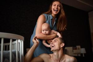 les jeunes parents s'amusent avec leur petit fils photo