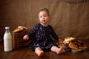 petite fille dans la cuisine mange des pâtisseries sucrées. photo