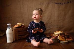 petite fille dans la cuisine mange des pâtisseries sucrées. photo