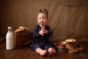 petite fille dans la cuisine mange des pâtisseries sucrées. photo