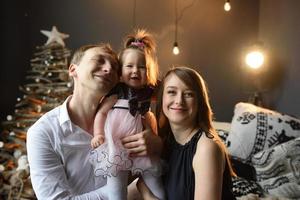 père maman et leur petite fille d'un an s'amusent ensemble avant noël. photo