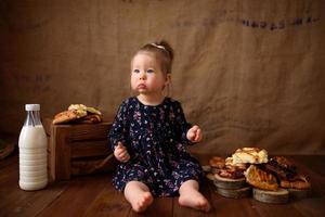 petite fille dans la cuisine mange des pâtisseries sucrées. photo