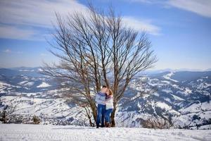 couple d'amoureux jouant ensemble dans la neige en plein air. vacances d'hiver à la montagne. homme et femme portant des vêtements tricotés s'amusant le week-end. photo