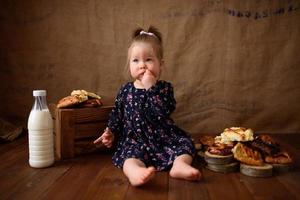 petite fille dans la cuisine mange des pâtisseries sucrées. photo