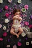 portrait d'une douce petite fille avec une couronne de fleurs sur la tête à l'intérieur photo