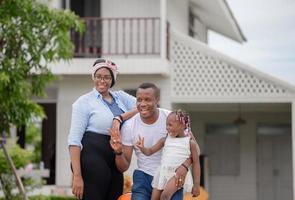 joyeuse famille afro-américaine avec bagages quittant la maison pour les vacances, concepts de famille de bonheur photo
