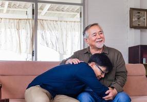 père asiatique âgé donne des conseils à son fils adulte dans le salon, père âgé et fils d'âge moyen assis se détendre dans le salon, concepts de famille de bonheur photo