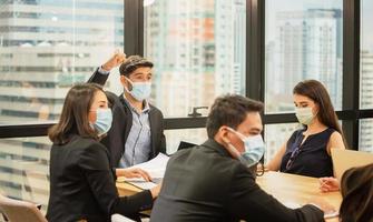 concept de réussite et de travail d'équipe, groupe de jeunes gens d'affaires portant un masque de protection et se réunissant au bureau photo