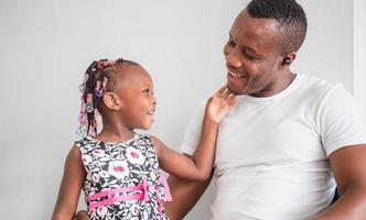 joyeux père et fille afro-américains jouant dans le salon, concepts de famille de bonheur photo