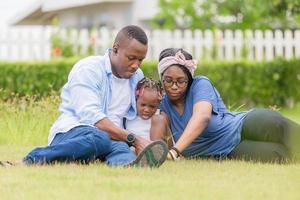 famille afro-américaine appréciant dans le parc, heureux père mère et fille jouant ensemble en plein air, concepts de famille de bonheur photo