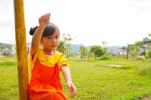 jolie petite fille porte une tenue gokowa jaune-orange, mugunghwa dans un parc public. robe de mode pour filles et adolescentes. photo