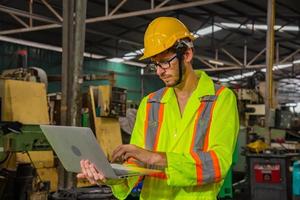 ingénierie de l'industrie et travail d'équipe portant un contrôle uniforme de sécurité faisant fonctionner la machine de meulage de tour travaillant dans l'usine de l'industrie. photo