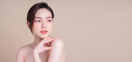 jolie jeune femme asiatique à la peau fraîche. soins du visage, traitement du visage, peau de beauté femme isolée sur fond blanc. cosmétologie, beauté de la peau et concept cosmétique photo