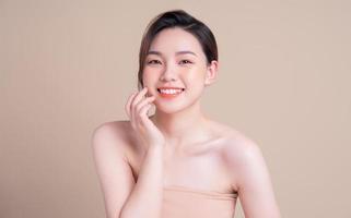 jolie jeune femme asiatique à la peau fraîche. soins du visage, traitement du visage, peau de beauté femme isolée sur fond blanc. cosmétologie, beauté de la peau et concept cosmétique photo