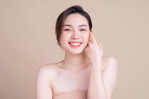 jolie jeune femme asiatique à la peau fraîche. soins du visage, traitement du visage, peau de beauté femme isolée sur fond blanc. cosmétologie, beauté de la peau et concept cosmétique photo