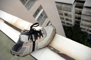 chaussures restantes tristes au bord d'un toit de bâtiment photo