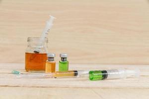 seringue et médicament liquide sur table en bois. photo