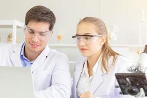 le concept de chercheurs en soins de santé, de chercheurs travaillant dans des laboratoires de vie biologique, de jeunes chercheurs et de superviseurs masculins, et ont une belle lumière orange photo