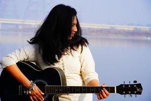 jeune femme jouant de la guitare acoustique photo