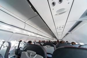 panneau de commande de climatisation d'avion au-dessus des sièges. air étouffant dans la cabine de l'avion avec des gens. nouvelle compagnie aérienne à bas prix. photo