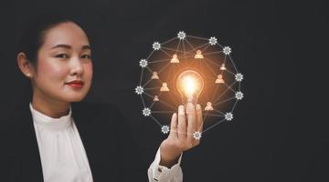 femme main tenant une ampoule avec ligne connectée et travaillant sur le bureau, la créativité et l'innovation sont les clés du succès.concept de nouvelle idée et d'innovation avec énergie et puissance, travail à domicile, photo