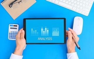 main à l'aide d'une tablette et d'un ordinateur portable analysant les données de vente et le graphique de croissance économique. stratégie d'entreprise. le marketing numérique. concept de technologie d'innovation d'entreprise photo