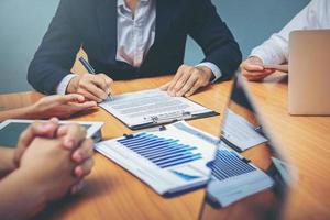 un homme d'affaires signe un contrat lors d'une réunion d'affaires et passe de l'argent après des négociations avec des partenaires commerciaux. mise au point sélectionnée photo