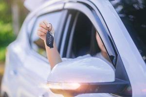 jeune femme asiatique prenant la clé de la voiture, système sans clé pour démarrer le moteur de la voiture. mise au point sélectionnée photo